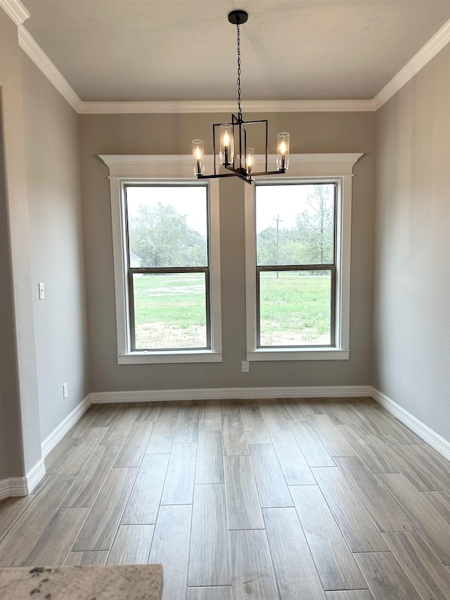 unfurnished dining area with a notable chandelier, ornamental molding, and a wealth of natural light