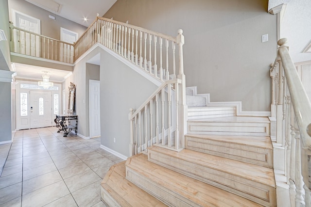 stairway featuring a high ceiling and tile patterned floors