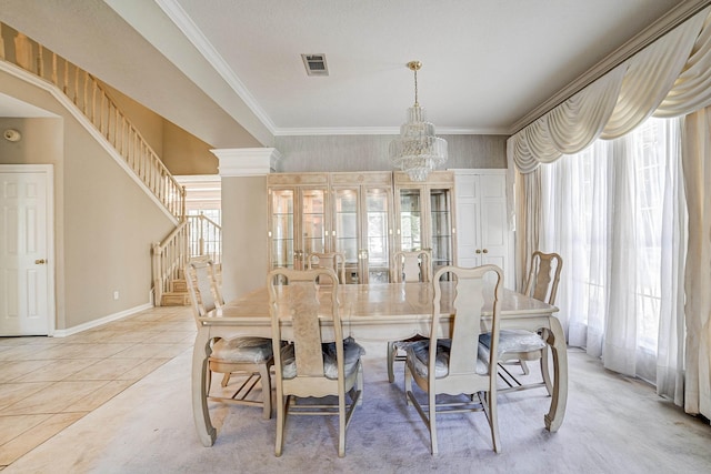 tiled dining room featuring plenty of natural light, decorative columns, and an inviting chandelier