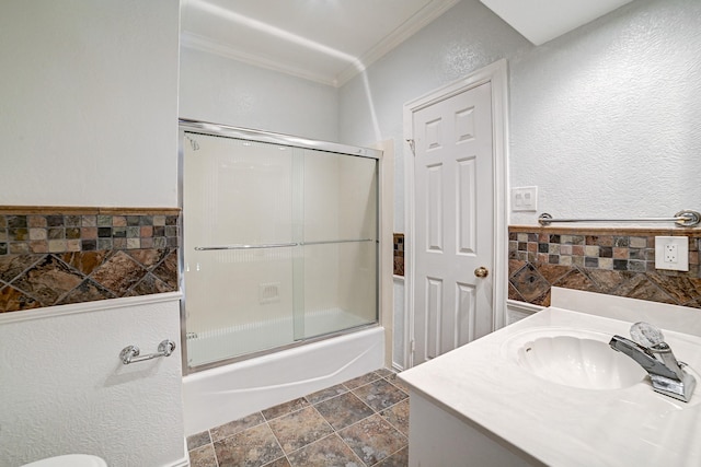 bathroom featuring crown molding, vanity, and bath / shower combo with glass door