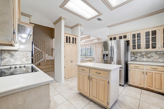 kitchen with tasteful backsplash, stainless steel fridge, a center island, and black electric stovetop