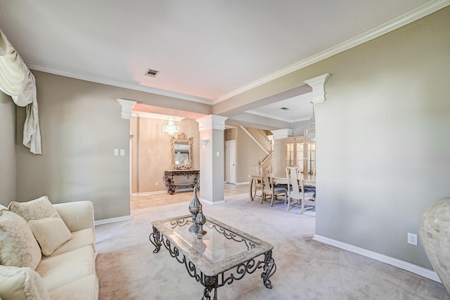 living room featuring light colored carpet, ornate columns, ornamental molding, and a notable chandelier