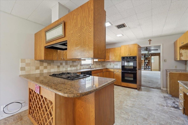 kitchen featuring tasteful backsplash, visible vents, a peninsula, brown cabinetry, and black appliances