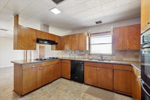 kitchen featuring visible vents, a sink, black appliances, under cabinet range hood, and brown cabinets