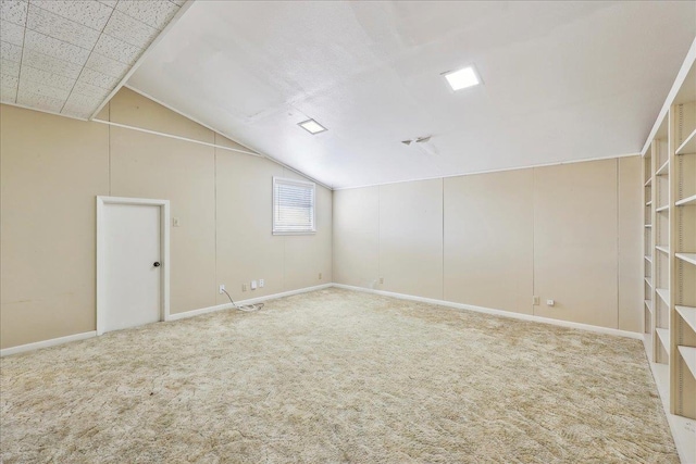 carpeted spare room featuring vaulted ceiling