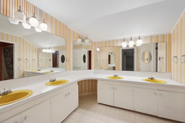 full bathroom with wallpapered walls and a sink