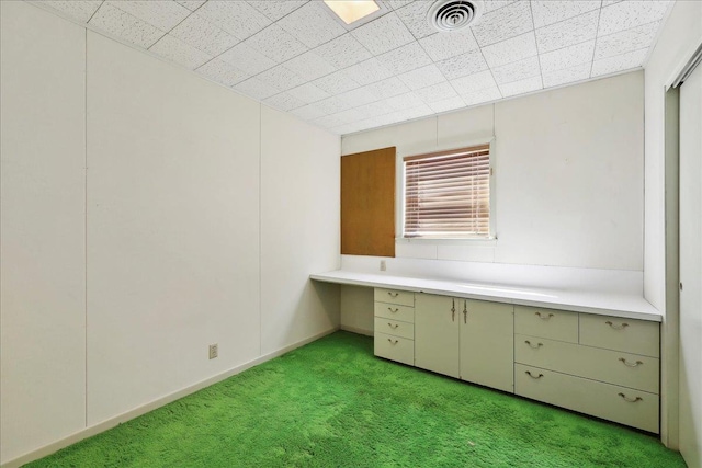 unfurnished office featuring visible vents, light colored carpet, and built in study area