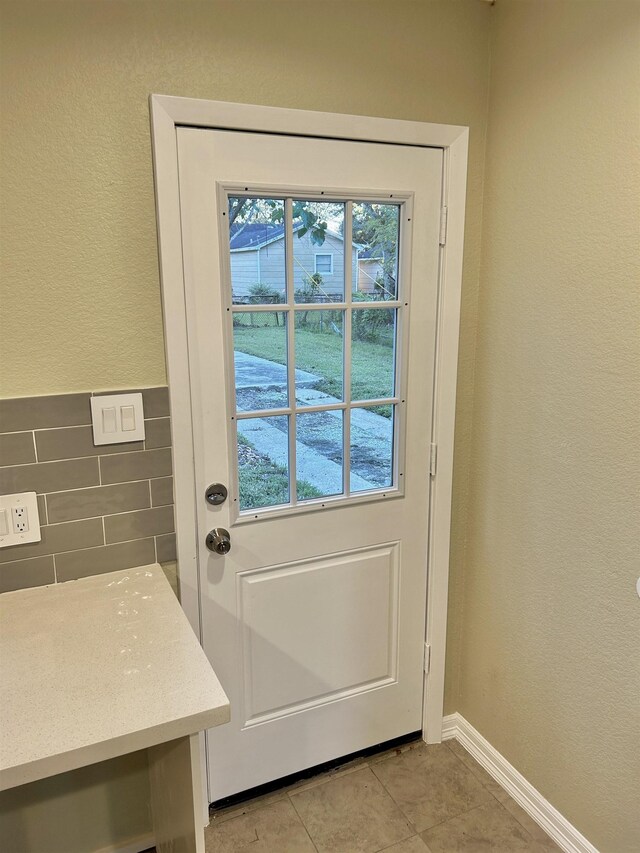 doorway to outside with light tile patterned floors