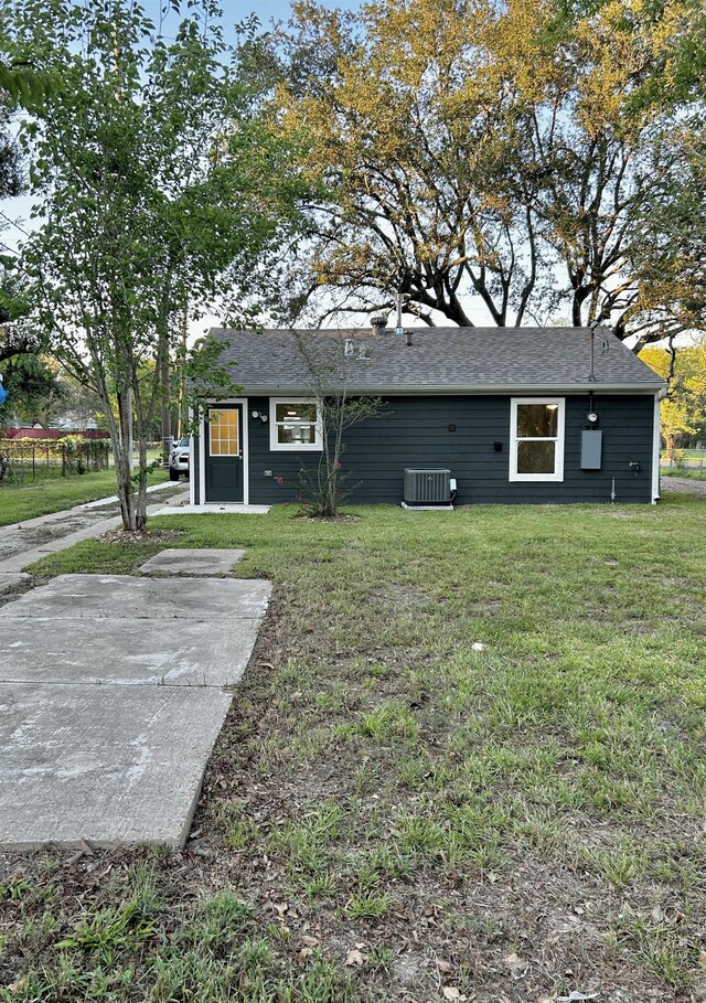 back of property featuring a lawn and central AC unit