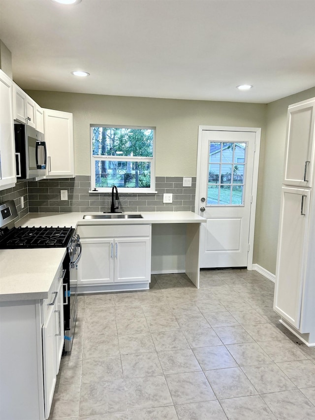 kitchen with white cabinets, sink, light tile patterned floors, and stainless steel appliances