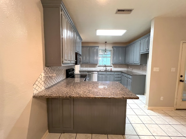 kitchen featuring kitchen peninsula, black stove, sink, and decorative backsplash