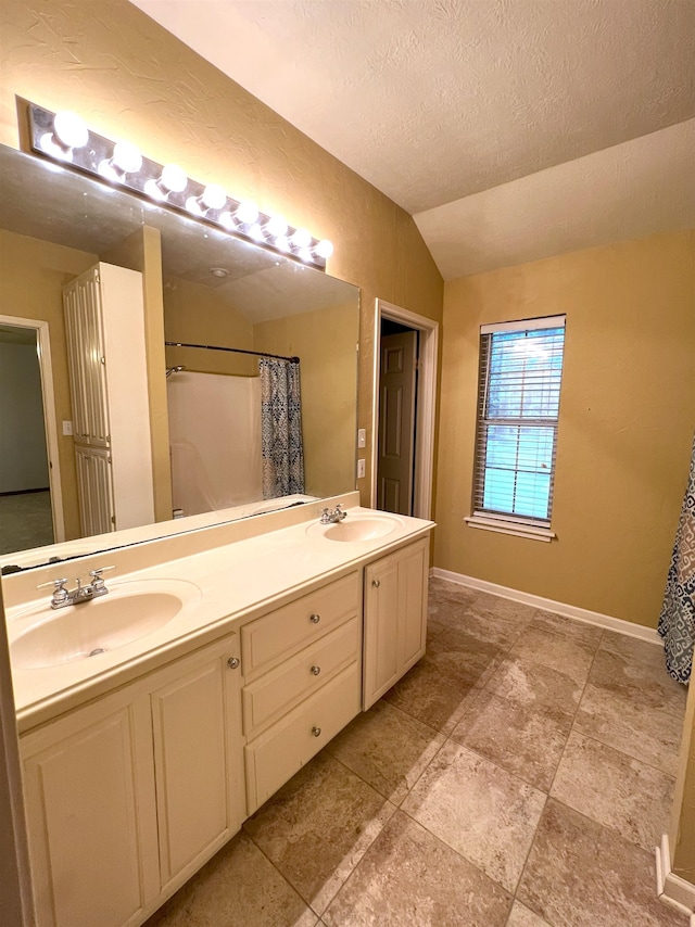 bathroom with vanity, a textured ceiling, vaulted ceiling, and curtained shower