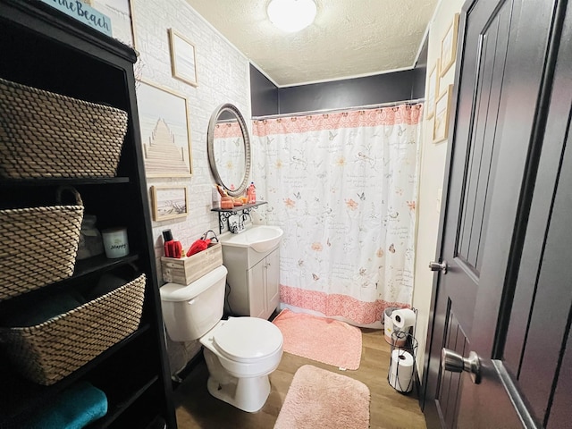 bathroom with toilet, a shower with curtain, wood finished floors, a textured ceiling, and vanity