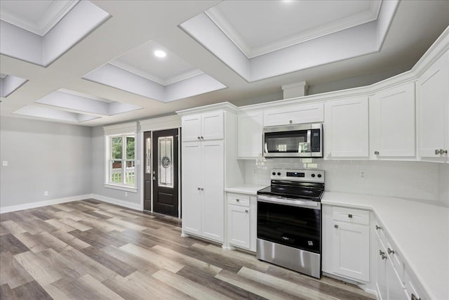8679 Massey Lake Rd, Silsbee, TX 77656 - kitchen featuring appliances with stainless steel finishes, light wood-style flooring, white cabinetry, light countertops, and backsplash