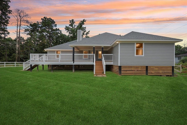 8679 Massey Lake Rd, Silsbee, TX 77656 - back of house at dusk with stairway, a shingled roof, a chimney, and a deck