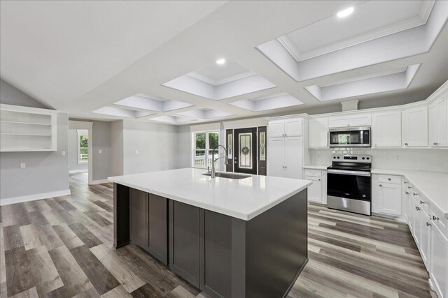 8679 Massey Lake Rd, Silsbee, TX 77656 - kitchen with appliances with stainless steel finishes, wood finished floors, healthy amount of natural light, an island with sink, and beam ceiling