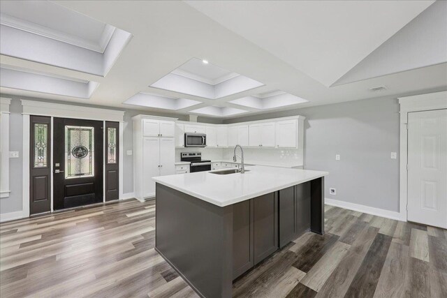 8679 Massey Lake Rd, Silsbee, TX 77656 - kitchen with appliances with stainless steel finishes, light countertops, white cabinetry, light wood-style flooring, and coffered ceiling