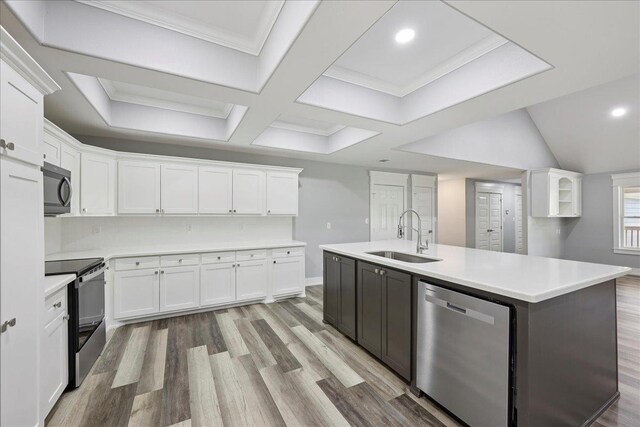 8679 Massey Lake Rd, Silsbee, TX 77656 - kitchen with stainless steel appliances, white cabinets, light wood finished floors, an island with sink, and light countertops