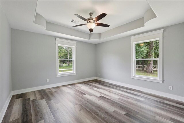 8679 Massey Lake Rd, Silsbee, TX 77656 - empty room featuring a tray ceiling, wood finished floors, and ceiling fan