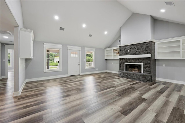 8679 Massey Lake Rd, Silsbee, TX 77656 - unfurnished living room featuring a stone fireplace, wood finished floors, high vaulted ceiling, and recessed lighting