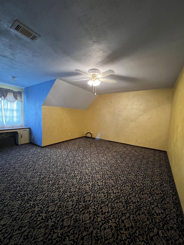 bonus room with a ceiling fan, carpet flooring, and a textured ceiling