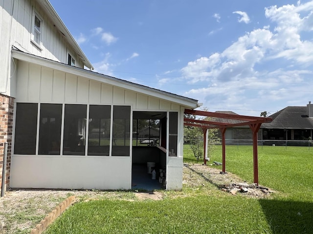 rear view of property featuring a lawn and a sunroom