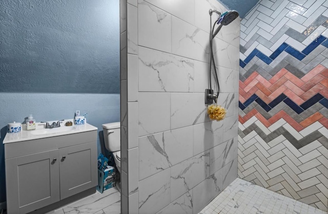 9655 Grapevine Dr, Orange, TX 77630 - bathroom featuring a tile shower, vanity, toilet, marble finish flooring, and a textured wall