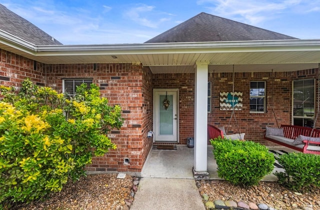 9655 Grapevine Dr, Orange, TX 77630 - property entrance with brick siding, a porch, and roof with shingles