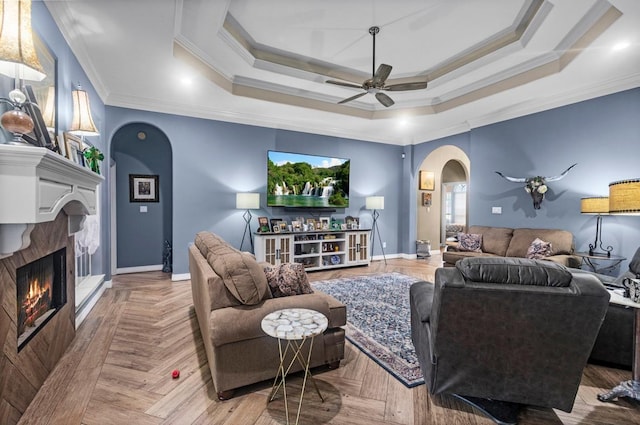 9655 Grapevine Dr, Orange, TX 77630 - living room featuring arched walkways, crown molding, ceiling fan, a fireplace, and a tray ceiling