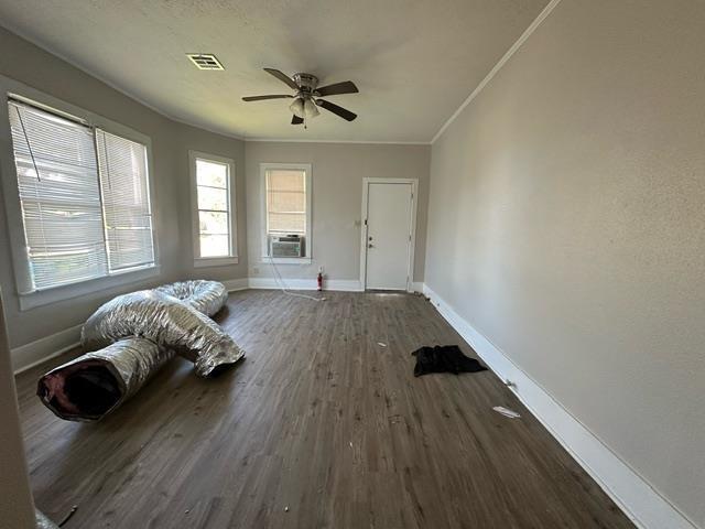 unfurnished bedroom with ceiling fan, crown molding, cooling unit, and dark hardwood / wood-style floors