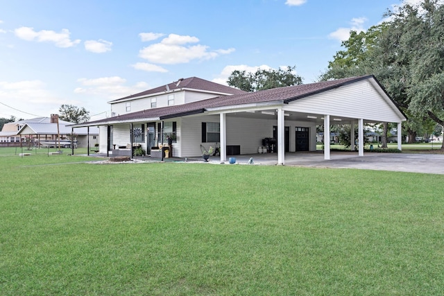 back of house with a carport, covered porch, and a yard