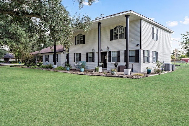 back of property with a yard and central AC