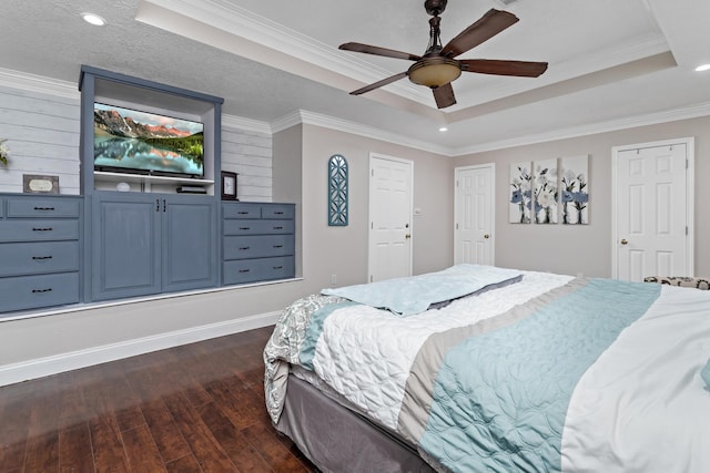 bedroom with dark hardwood / wood-style floors, a raised ceiling, ceiling fan, and ornamental molding