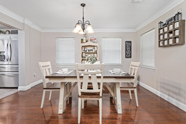 dining room featuring dark hardwood / wood-style floors, ornamental molding, a textured ceiling, and an inviting chandelier