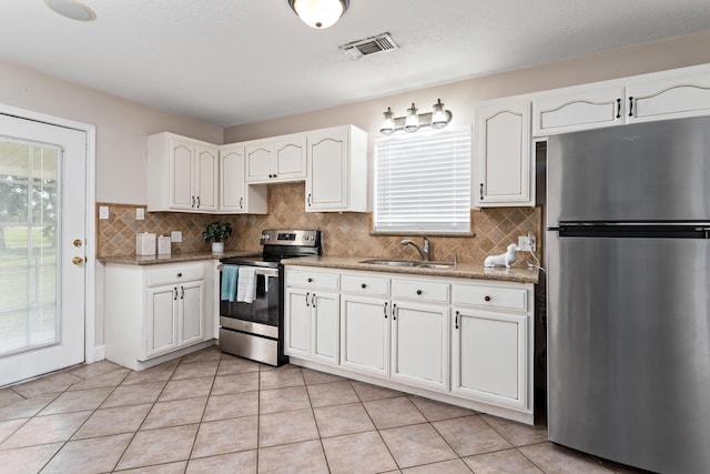 kitchen with light stone countertops, white cabinetry, sink, stainless steel appliances, and light tile patterned floors