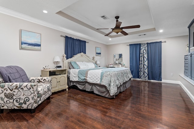 bedroom with hardwood / wood-style flooring, a raised ceiling, ceiling fan, and ornamental molding