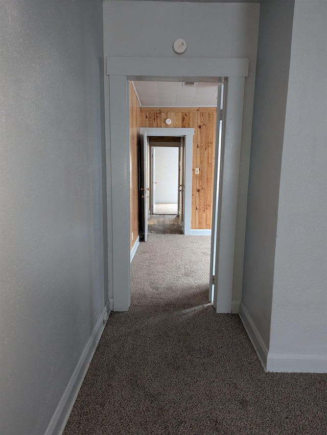 hall with wooden walls and carpet floors