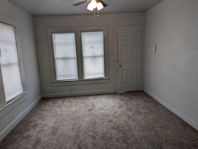 empty room featuring a wealth of natural light, ceiling fan, and light colored carpet