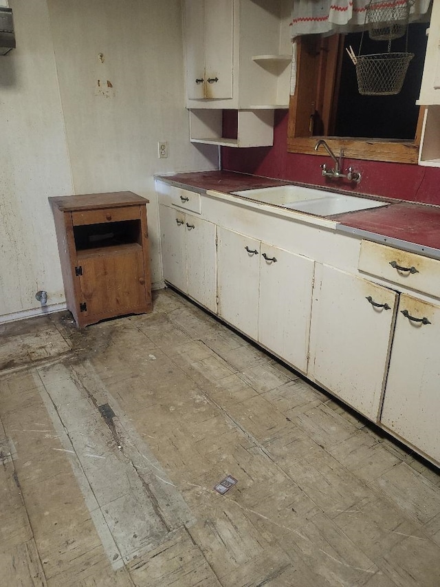 kitchen featuring white cabinetry and sink