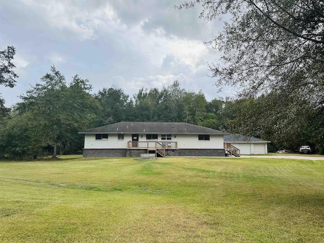 view of front of property with a garage, a front lawn, an outdoor structure, and a wooden deck