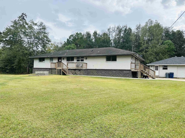 rear view of property featuring a lawn and a wooden deck