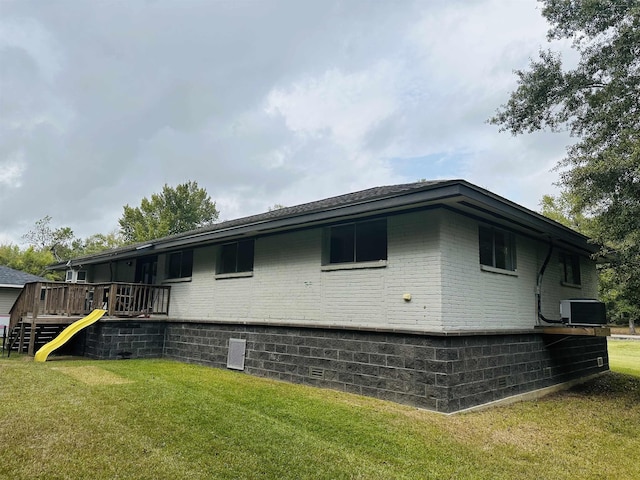 view of side of home featuring central AC unit and a lawn