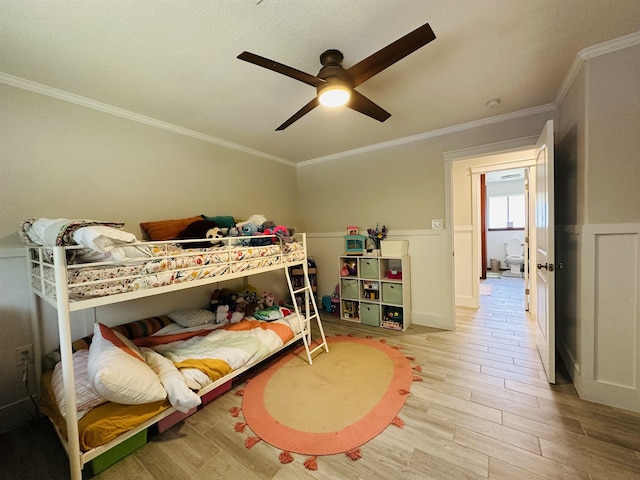 bedroom featuring light wood-type flooring, ceiling fan, and ornamental molding