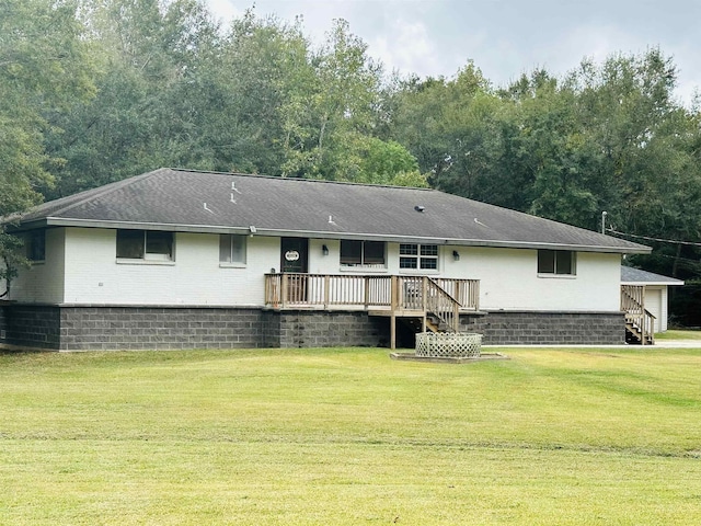 back of property featuring a deck and a yard