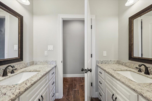 145 Colonial Estates Dr, Bridge City, TX 77611 - bathroom featuring two vanities and baseboards