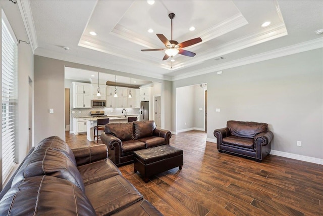 145 Colonial Estates Dr, Bridge City, TX 77611 - living area with a raised ceiling, ceiling fan, dark wood-type flooring, ornamental molding, and baseboards