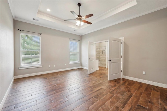 145 Colonial Estates Dr, Bridge City, TX 77611 - unfurnished bedroom featuring a raised ceiling, dark wood-style floors, ornamental molding, and multiple windows