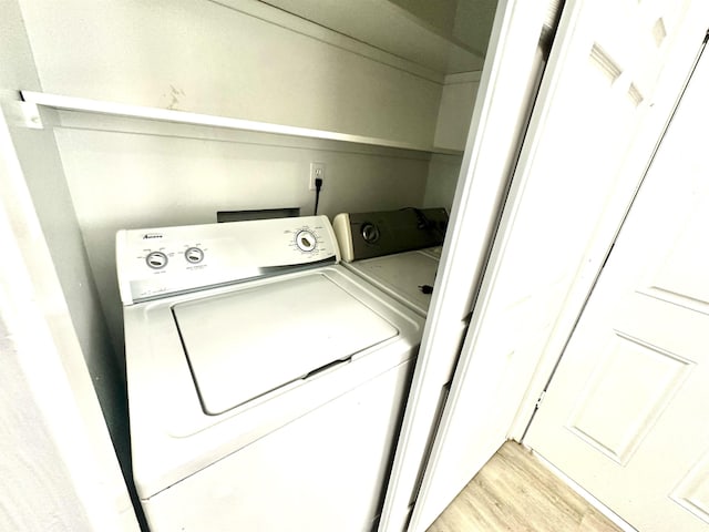 laundry room featuring washer and clothes dryer and light hardwood / wood-style floors