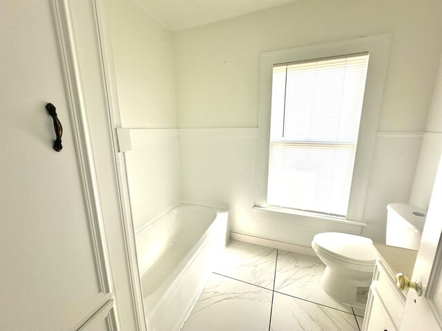 bathroom featuring a tub, vanity, and toilet