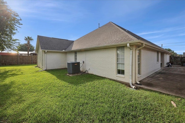 211 Skylark Ave, Bridge City, TX 77611 - rear view of house featuring cooling unit, brick siding, roof with shingles, and a patio